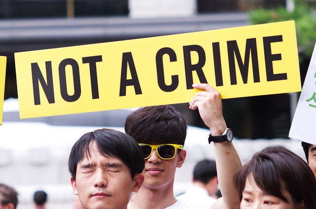 Etelä-Koreassa osoitetaan mieltä aseistakieltäytymisoikeuden puolesta. Mielenosoittaja pitelee kylttiä jossa lukee: "Not a Crime"